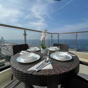 a table with plates and utensils on a balcony at Sea View Villa فيلا إطلالة بحرية in Jeddah