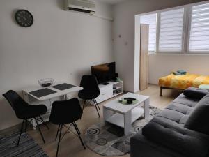 a living room with a couch and a table and chairs at Una Studio Apartman in Sombor