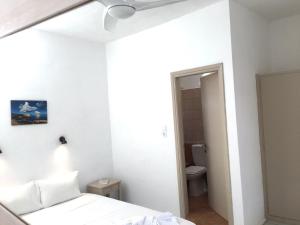 ein weißes Schlafzimmer mit Bett und Badezimmer in der Unterkunft Pavlosx2 in Folegandros Chora