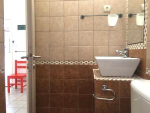 ein Badezimmer mit Waschbecken und einem roten Hocker in der Unterkunft Pavlosx2 in Folegandros Chora + 11 Fotos