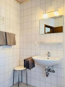 a bathroom with a sink and a mirror and stools at Historisches Winzerhaus Lieser in Lieser