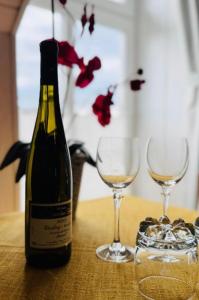 a bottle of wine and two glasses on a table at Historisches Winzerhaus Lieser in Lieser