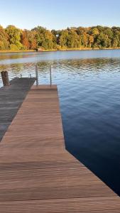 a dock on a lake with ducks on the water at Ferienhaus Seekutter mit eigenem Seezugang in Malchow