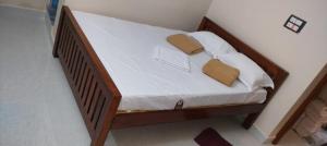 a wooden bed with two pillows on top of it at gururesidency in Tiruvannāmalai