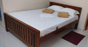 a wooden bed with two pillows on top of it at gururesidency in Tiruvannāmalai