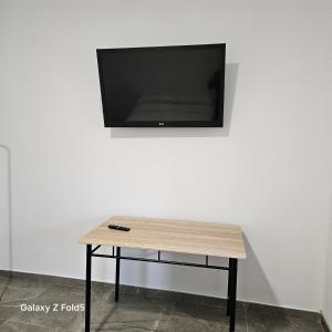 a table with a flat screen tv on a wall at Aires de Benatae in Benatae