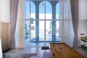 a pool table in a room with a large window at Luma & Malta PoolVilla Cha-am in Sathani Nong Ta Phot