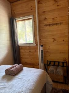 a bedroom with a bed with towels on it at The Bloom Farm Cottage in Carrajung South +54 photos