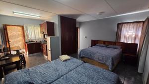 a hotel room with two beds and a kitchen at Beginners Cove Lodge in Nelspruit +26 photos
