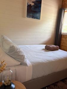 a bed with a towel on it in a room at The Bloom Farm Cottage in Carrajung South