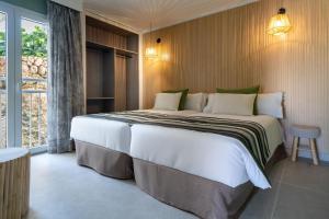 ein großes Bett in einem Zimmer mit Fenster in der Unterkunft MarSenses Natura Olea Hotel - Adults Only in Cala d´Or + 79 Fotos