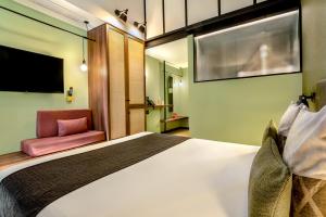 ein Hotelzimmer mit einem Bett und einem Stuhl in der Unterkunft Hotel Orangine in Hospitalet de Llobregat