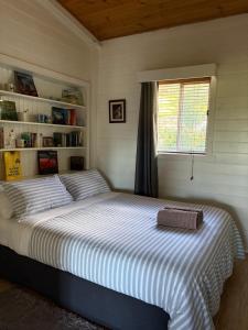a bedroom with a large bed with a window at The Bloom Farm Cottage in Carrajung South