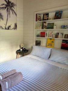 a bedroom with a large bed with blue and white stripes at The Bloom Farm Cottage in Carrajung South