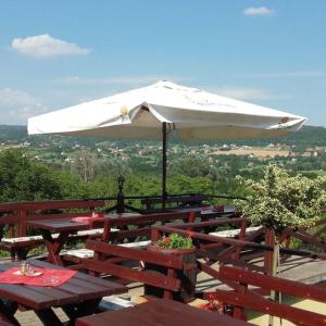 a white umbrella sitting on top of wooden tables at Vilmos Pince Fogadó in Hévíz