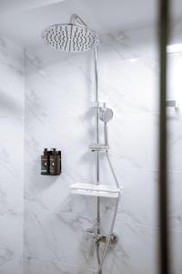 a bathroom with a shower with white marble walls at The Wang Yaowarat Hotel in Bangkok +49 photos