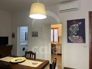 a dining room with a table and a painting on the wall at Casa Estela By Cala Salento in Porto Cesareo