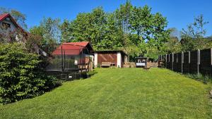 a yard with a fence and a house at Krkonošská chaloupka in Černý Dŭl