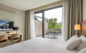 a hotel room with a bed and a large window at MOVE Hotels Venezia Nord in Mogliano Veneto