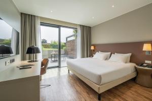 a hotel room with a bed and a desk and a window at MOVE Hotels Venezia Nord in Mogliano Veneto