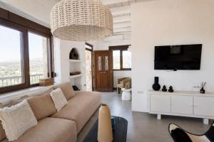 a living room with a couch and a tv at Villa Ikaros in Agia Triada
