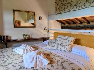 a bedroom with a bed with white sheets and a mirror at Sant'Antonio Country Resort in Montepulciano +162 photos