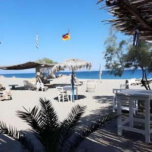 a beach with chairs and tables on the sand at Camping Dias in Gythio