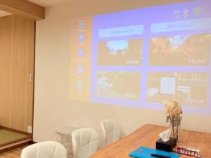 a projection screen in a room with a table and chairs at クリスタルSky tree Hotel in Tokyo