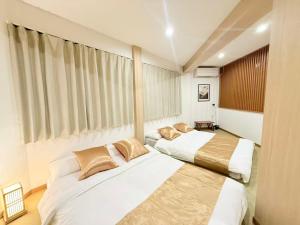 a bedroom with two beds and a window at クリスタルSky tree Hotel in Tokyo
