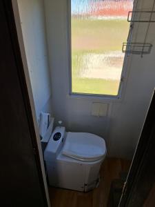 a small bathroom with a toilet and a window at Villavagn in Gärds Köpinge