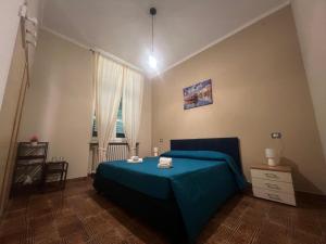 a bedroom with a blue bed and a window at Agriturismo Relais Kloe in Castel Boglione