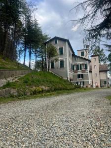 a large house on a hill with a gravel road at Agriturismo Relais Kloe in Castel Boglione +33 photos