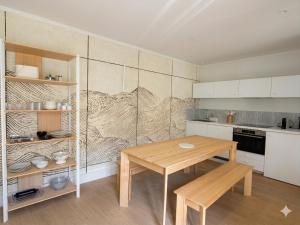 a small kitchen with a wooden table and a counter at Appartement avec jacuzzi et vue sur Pyramide in Vienne