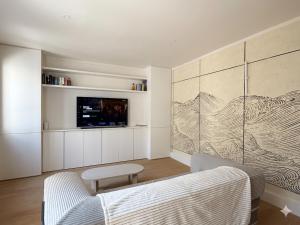 a living room with a couch and a tv at Appartement avec jacuzzi et vue sur Pyramide in Vienne