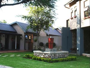 a house with a fountain in the front yard at Arotin Game Lodge in Brits