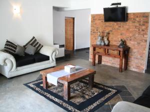 a living room with a couch and a coffee table at Arotin Game Lodge in Brits