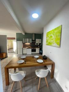a kitchen with a wooden table and white chairs at Loft im Fabrikstil mit 2 eigenen Schlafzimmern mit Wlan und Parkplatz in Groß-Umstadt