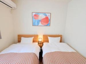 two beds sitting next to each other in a room at HIRO HOUSE Marugame - 丸亀駅徒歩5分 in Marugame +33 photos