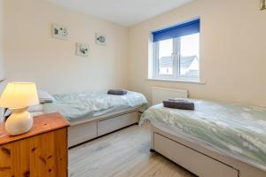 two twin beds in a room with a window at 2 Bed in Bideford oc-rives in Bideford