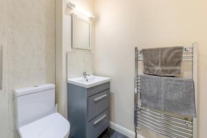 a bathroom with a toilet and a sink and a mirror at 2 Bed in Bideford oc-rives in Bideford