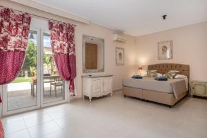 a bedroom with a bed and a sliding glass door at Celeste Sea View Home with Jacuzzi and BBQ in Psalidi