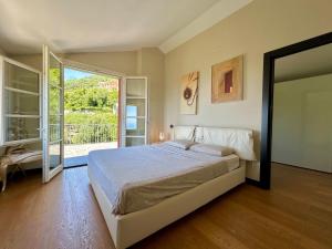 a bedroom with a bed and a sliding glass door at COGO, Premium Private Villa Vista Mare in Cogorno