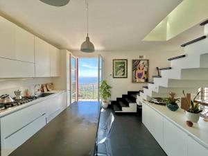 a kitchen with white cabinets and a spiral staircase at COGO, Premium Private Villa Vista Mare in Cogorno