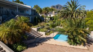 a resort with a swimming pool and palm trees at Agape Apartments in Somerset West