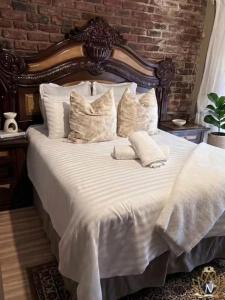 a large bed with white sheets and pillows at Nalana Guest House in Thaba Nchu