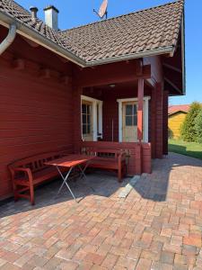 a red house with two benches and a table at Finnische Blockhäuser in Gartow