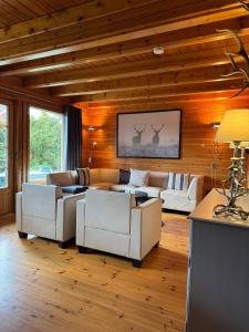 a living room with white furniture and wooden walls at Finnische Blockhäuser in Gartow
