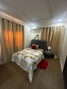a bedroom with a bed and a red pillow on it at Hope Apartments Surulere in Lagos