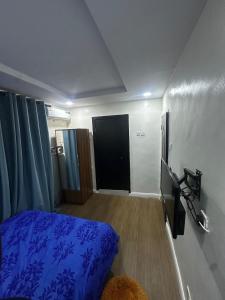 a bedroom with a blue bed and a black door at Hope Apartments Surulere in Lagos +4 photos