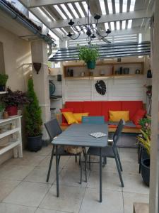 a patio with a table and chairs and a couch at Chambre César B&B- au 1er - Villa Chaumonty in Périgueux